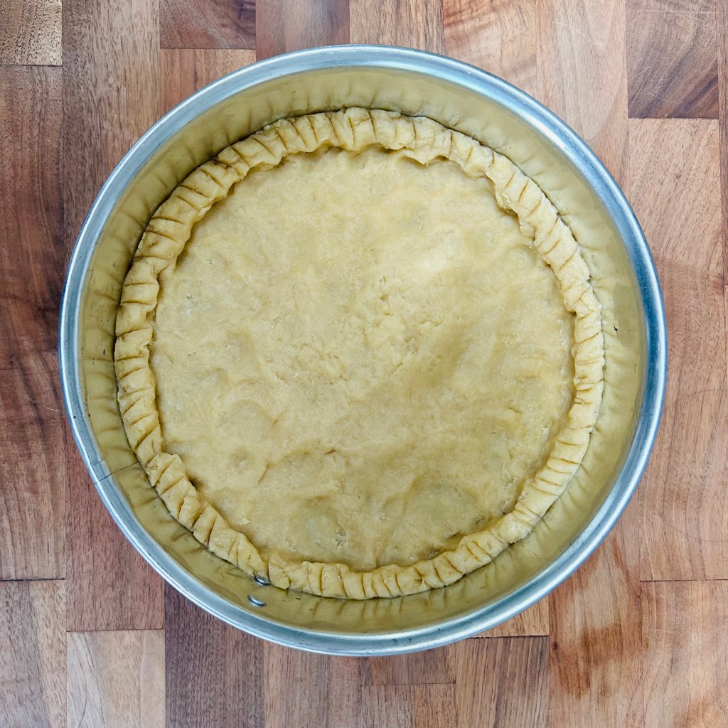 Pie dough pressed into a springform pan to make a tart. 
